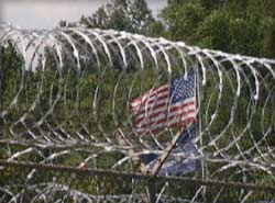 photo of barbed wire and an american flag