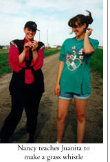 nancy teaches juanita to make a grass whistle