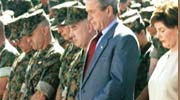 photo of the president and first lady praying with troops