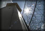 photo of a prison fence and tower