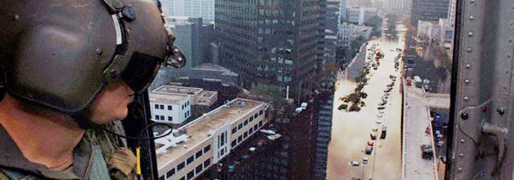 photo of a soldier looking out over flooded downtown new orleans